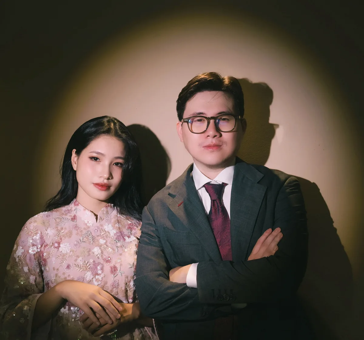 Hai đứa khoanh tay dưới ánh đèn spotlight